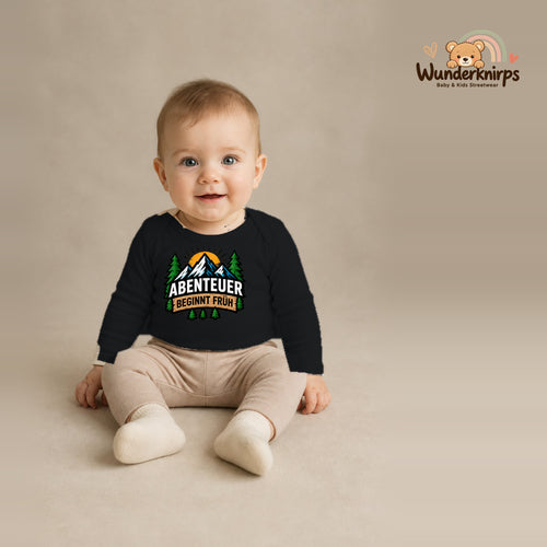 Babybody für Jungen in Schwarz mit Motiv „Abenteuer beginnt früh“, getragen von einem Kind – Wunderknirps.