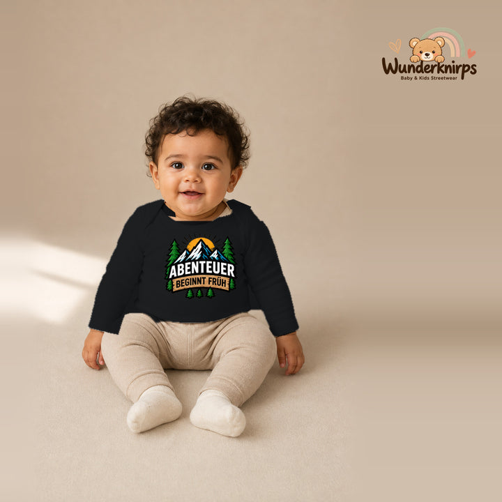 Babybody für Jungen in Schwarz mit Motiv „Abenteuer beginnt früh“, getragen von einem Kind – Wunderknirps.