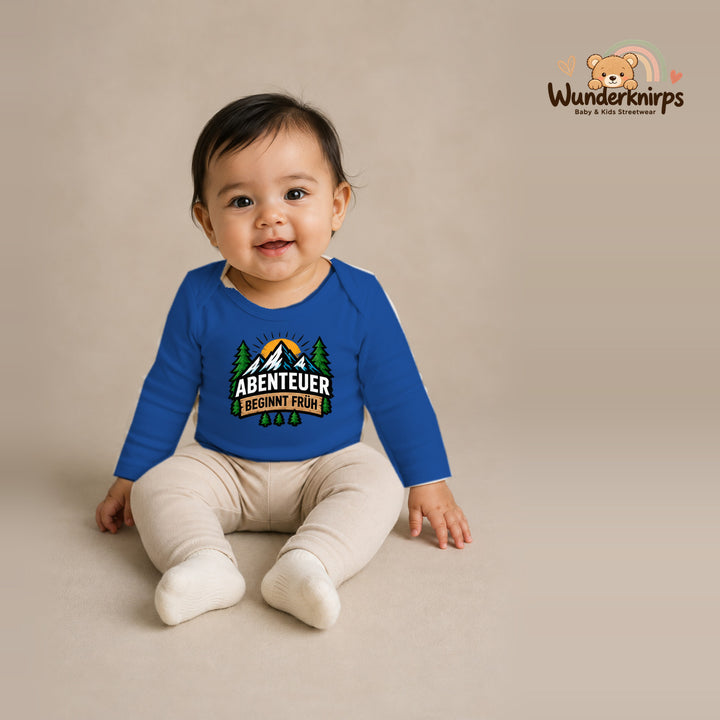 Babybody für Mädchen in Blau mit Motiv „Abenteuer beginnt früh“, getragen von einem Kind – Wunderknirps.