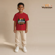 T-Shirt für Jungen in Rot mit Motiv „Abenteuer beginnt früh“, getragen von einem Kind – Wunderknirps.