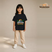 T-Shirt für Mädchen in Schwarz mit Motiv „Abenteuer beginnt früh“, getragen von einem Kind – Wunderknirps.