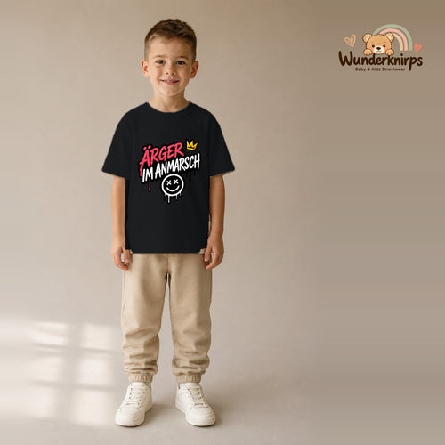 T-Shirt für Jungen in Schwarz mit Motiv „Ärger im Anmarsch“, getragen von einem Kind – Wunderknirps.