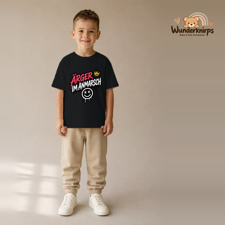 T-Shirt für Jungen in Schwarz mit Motiv „Ärger im Anmarsch“, getragen von einem Kind – Wunderknirps.