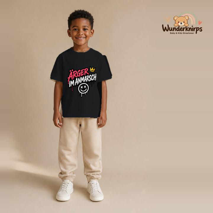 T-Shirt für Jungen in Schwarz mit Motiv „Ärger im Anmarsch“, getragen von einem Kind – Wunderknirps.
