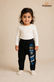 Affenmotiv Traumlook – Legend never follows – Babyhose für Mädchen: Schwarz mit Affenmotiv-Druck am Hosenbein – Wunderknirps.