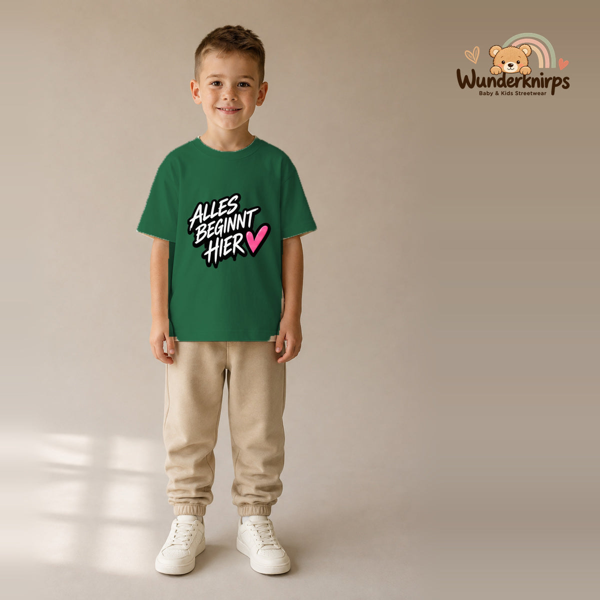 T-Shirt für Jungen in Grün mit Motiv „Alles beginnt hier“, getragen von einem Kind – Wunderknirps.