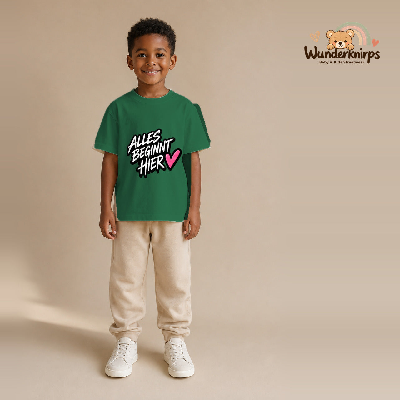 T-Shirt für Jungen in Grün mit Motiv „Alles beginnt hier“, getragen von einem Kind – Wunderknirps.
