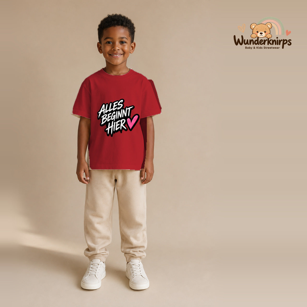 T-Shirt für Jungen in Rot mit Motiv „Alles beginnt hier“, getragen von einem Kind – Wunderknirps.