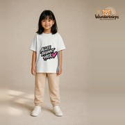 T-Shirt für Mädchen in Weiß mit Motiv „Alles beginnt hier“, getragen von einem Kind – Wunderknirps.