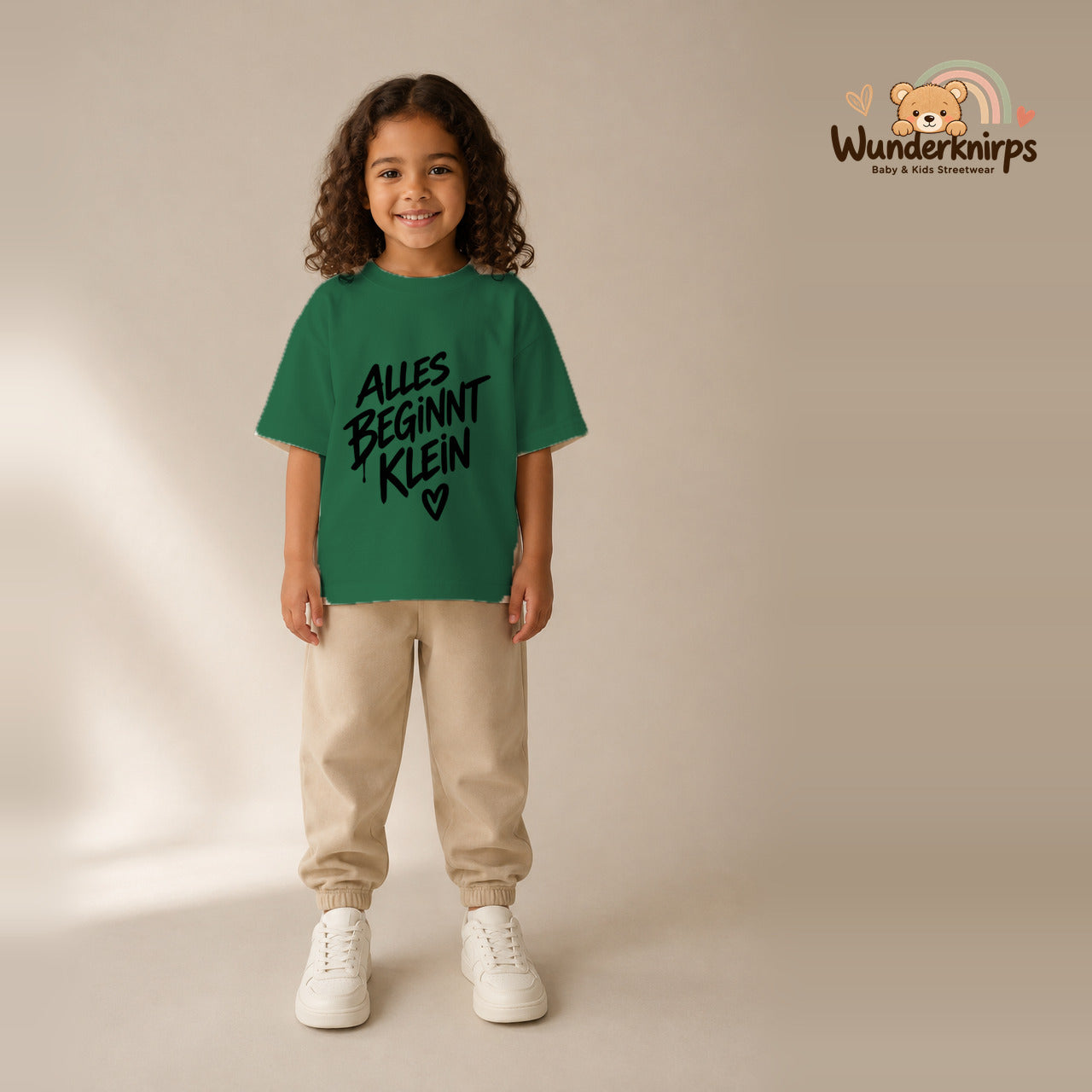 T-Shirt für Mädchen in Grün mit Motiv „Alles beginnt klein“, getragen von einem Kind – Wunderknirps.