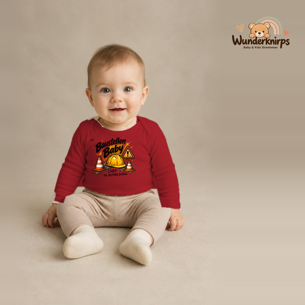 Babybody für Jungen in Rot mit Motiv „Baustellenbaby“, getragen von einem Kind – Wunderknirps.