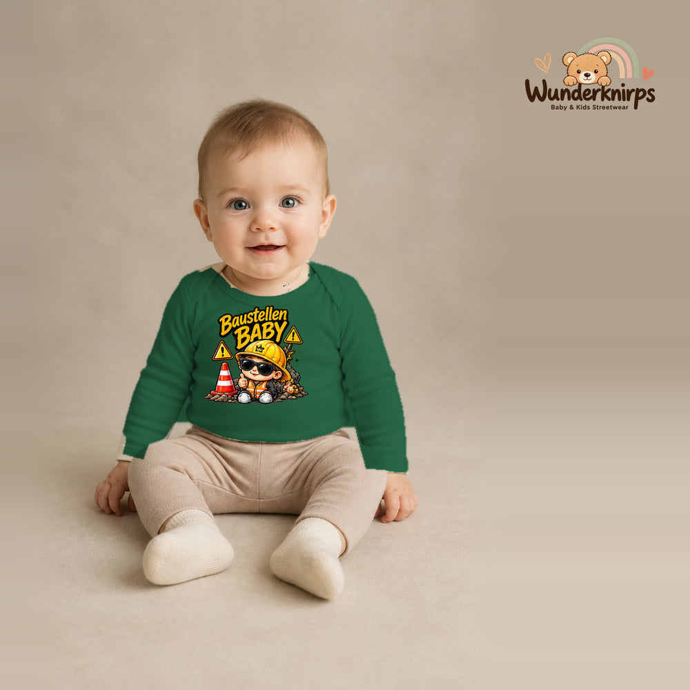 Babybody für Jungen in Grün mit Motiv „Baustellenbaby“, getragen von einem Kind – Wunderknirps.