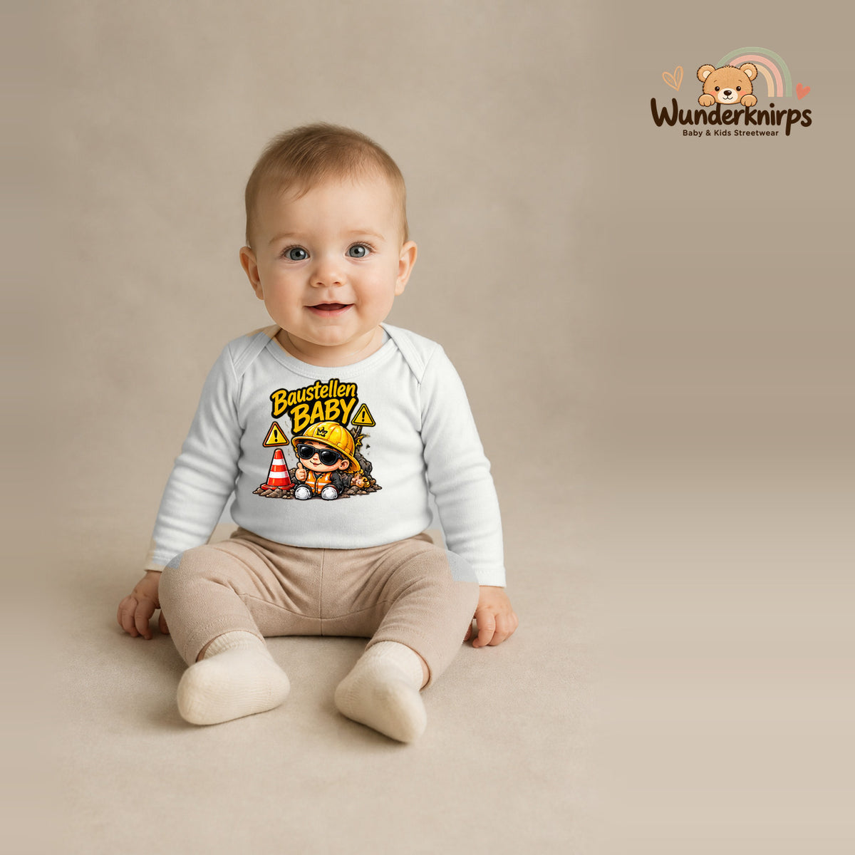 Babybody für Jungen in Weiß mit Motiv „Baustellenbaby“, getragen von einem Kind – Wunderknirps.
