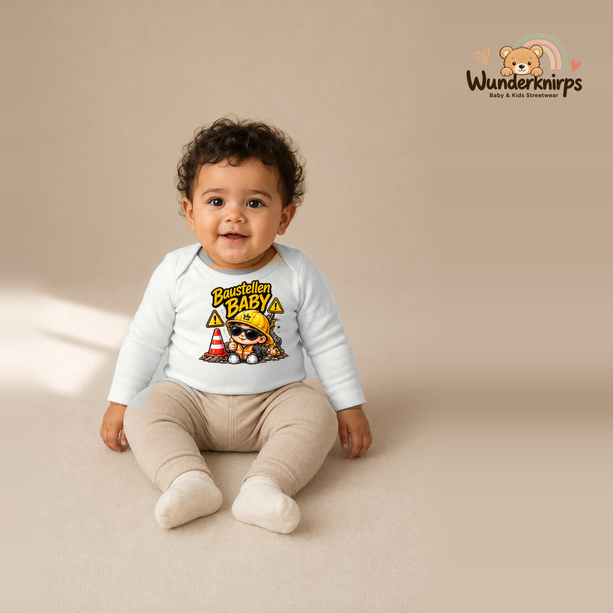 Babybody für Jungen in Weiß mit Motiv „Baustellenbaby“, getragen von einem Kind – Wunderknirps.