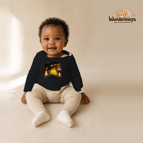 Babybody für Mädchen in Schwarz mit Motiv „Baustellenbaby“, getragen von einem Kind – Wunderknirps.