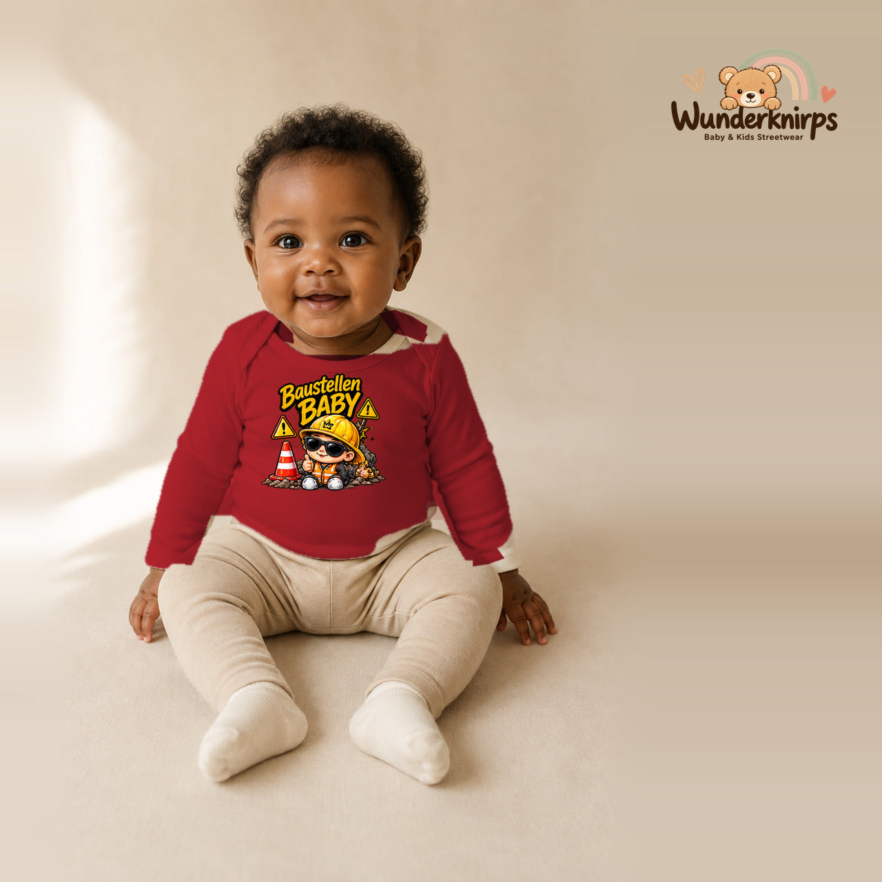 Babybody für Mädchen in Rot mit Motiv „Baustellenbaby“, getragen von einem Kind – Wunderknirps.