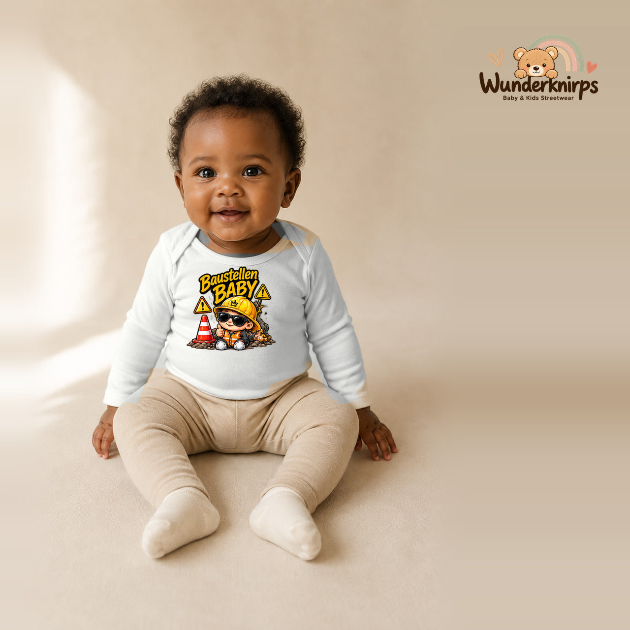 Babybody für Mädchen in Weiß mit Motiv „Baustellenbaby“, getragen von einem Kind – Wunderknirps.