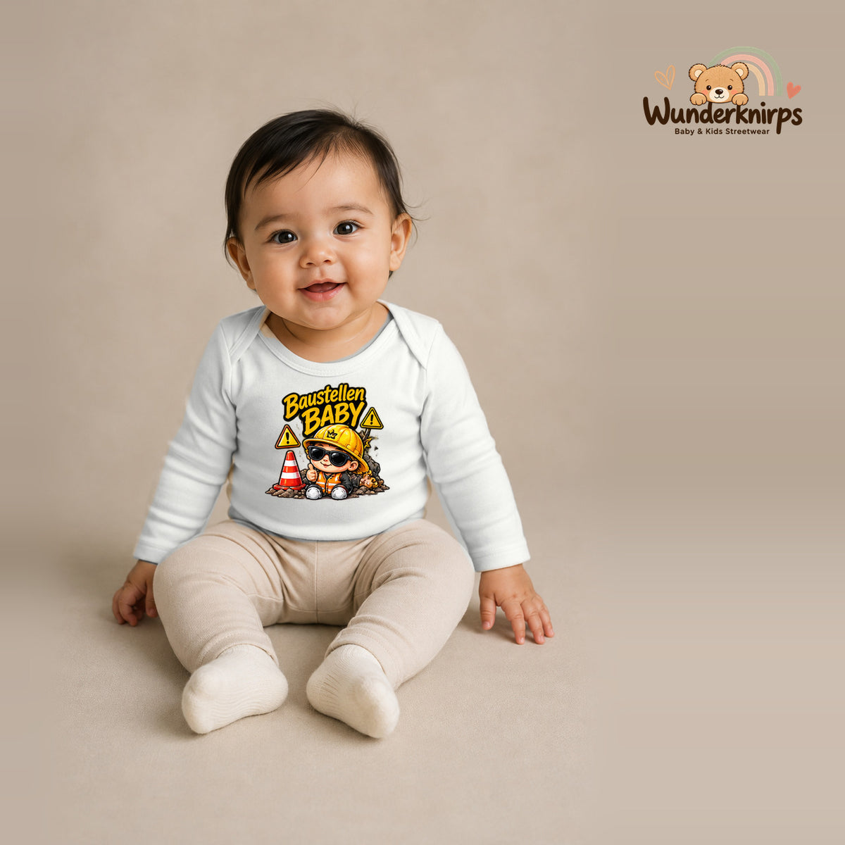 Babybody für Mädchen in Weiß mit Motiv „Baustellenbaby“, getragen von einem Kind – Wunderknirps.