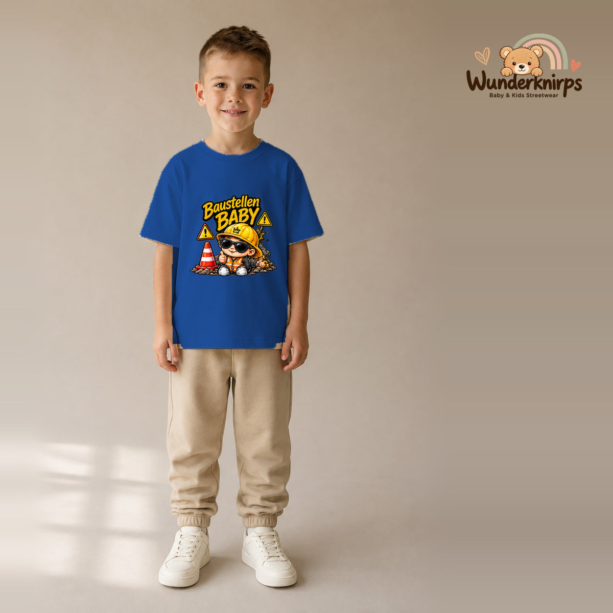 T-Shirt für Jungen in Blau mit Motiv „Baustellenbaby“, getragen von einem Kind – Wunderknirps.