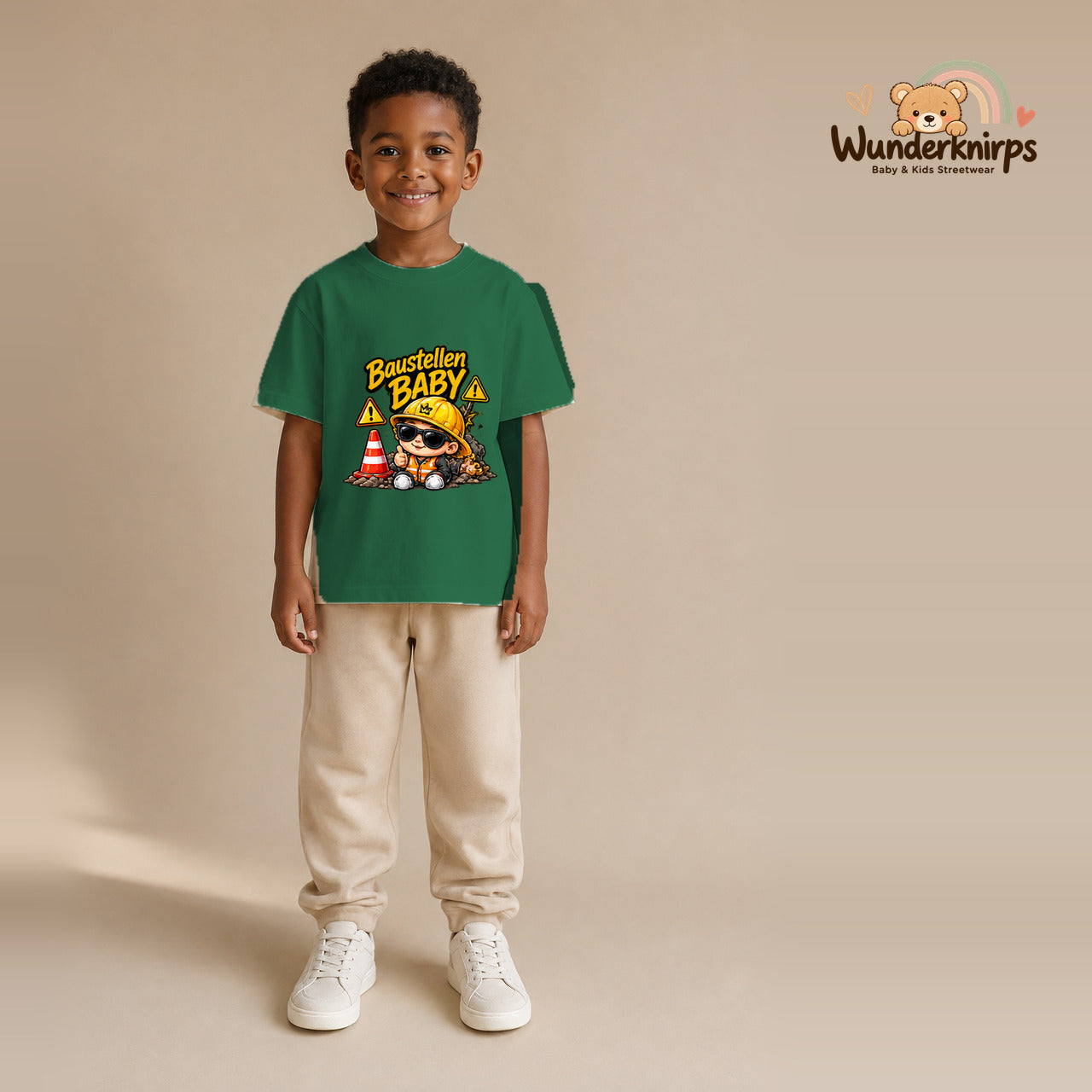 T-Shirt für Jungen in Grün mit Motiv „Baustellenbaby“, getragen von einem Kind – Wunderknirps.