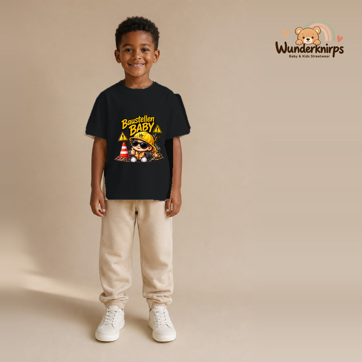 T-Shirt für Jungen in Schwarz mit Motiv „Baustellenbaby“, getragen von einem Kind – Wunderknirps.