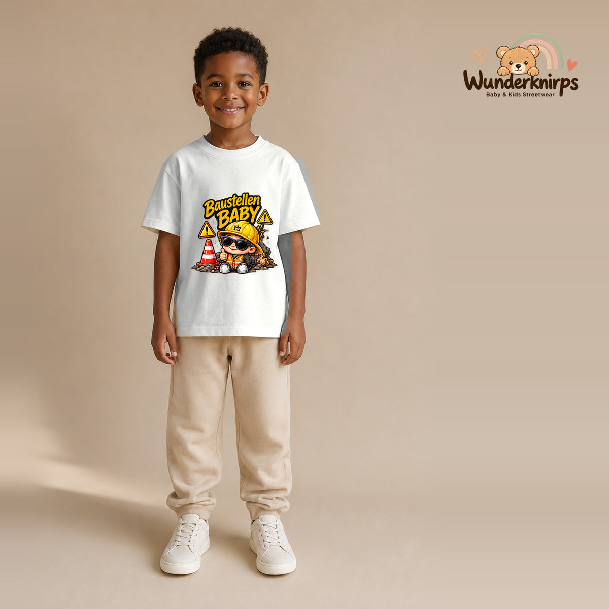 T-Shirt für Jungen in Weiß mit Motiv „Baustellenbaby“, getragen von einem Kind – Wunderknirps.