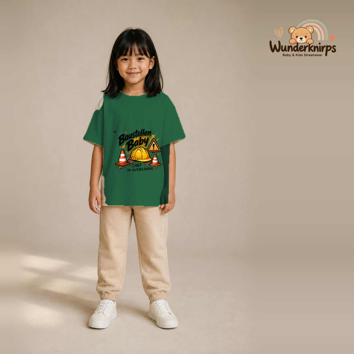T-Shirt für Mädchen in Grün mit Motiv „Baustellenbaby“, getragen von einem Kind – Wunderknirps.