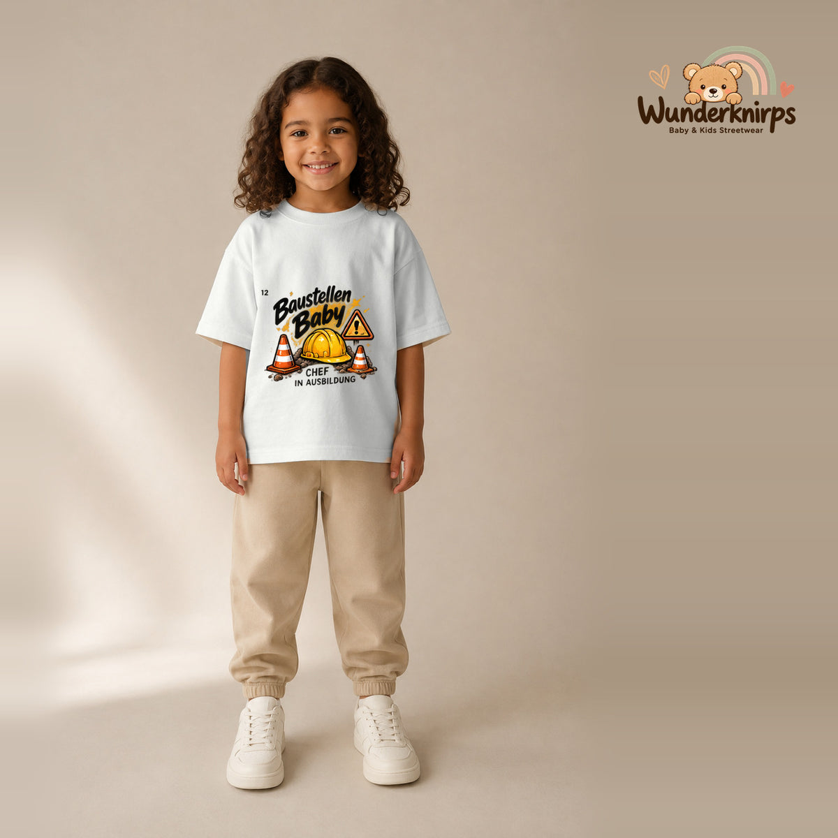 T-Shirt für Mädchen in Weiß mit Motiv „Baustellenbaby“, getragen von einem Kind – Wunderknirps.
