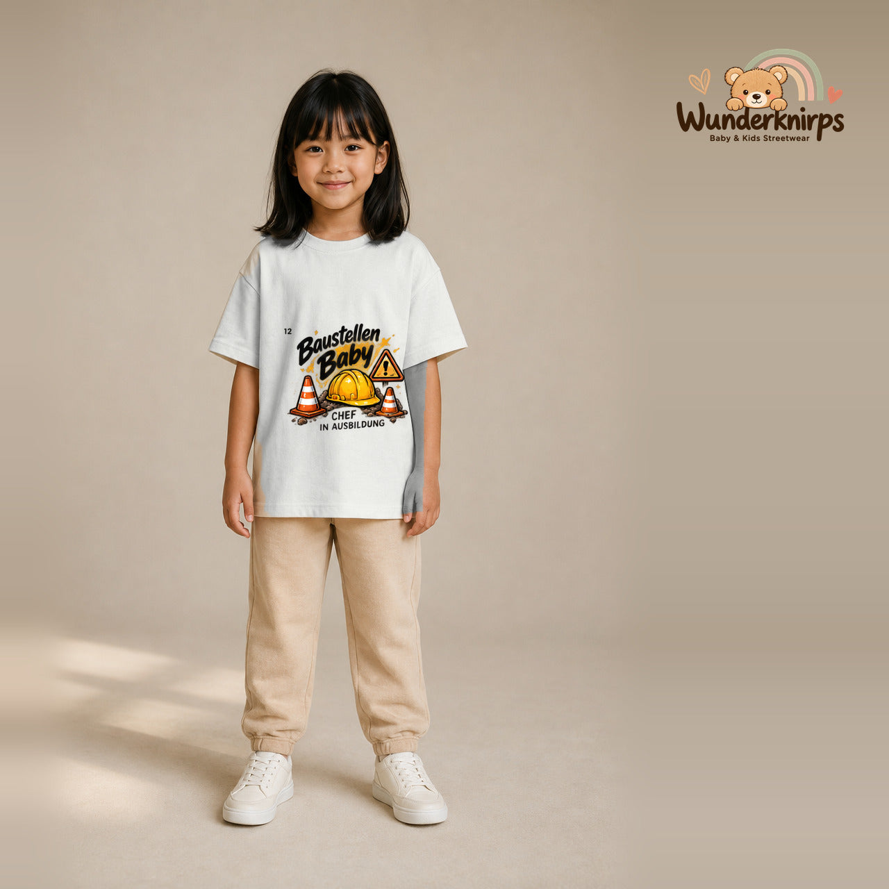 T-Shirt für Mädchen in Weiß mit Motiv „Baustellenbaby“, getragen von einem Kind – Wunderknirps.