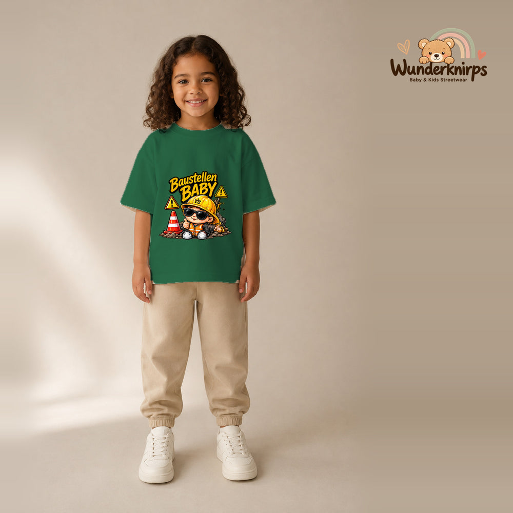T-Shirt für Mädchen in Grün mit Motiv „Baustellenbaby“, getragen von einem Kind – Wunderknirps.