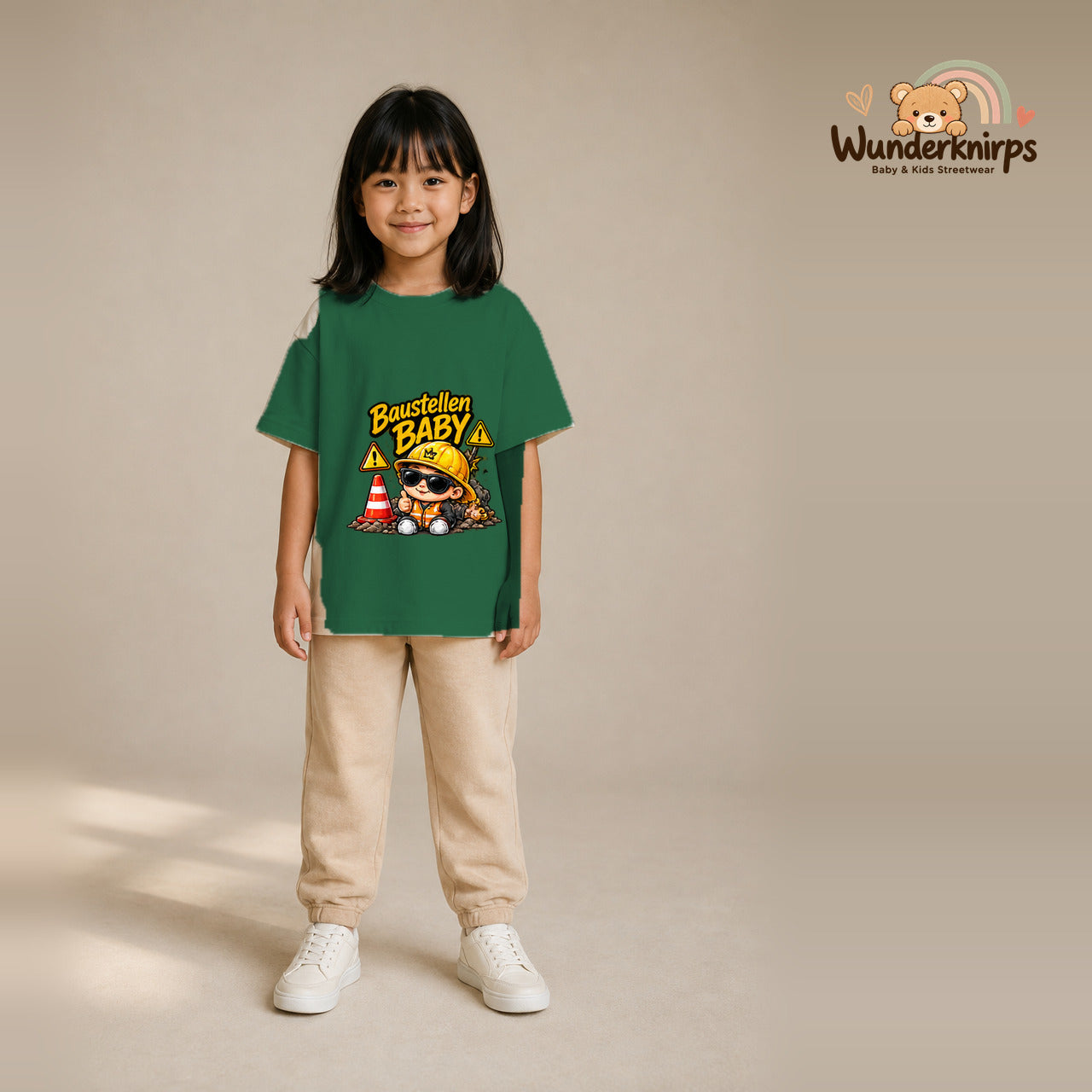 T-Shirt für Mädchen in Grün mit Motiv „Baustellenbaby“, getragen von einem Kind – Wunderknirps.