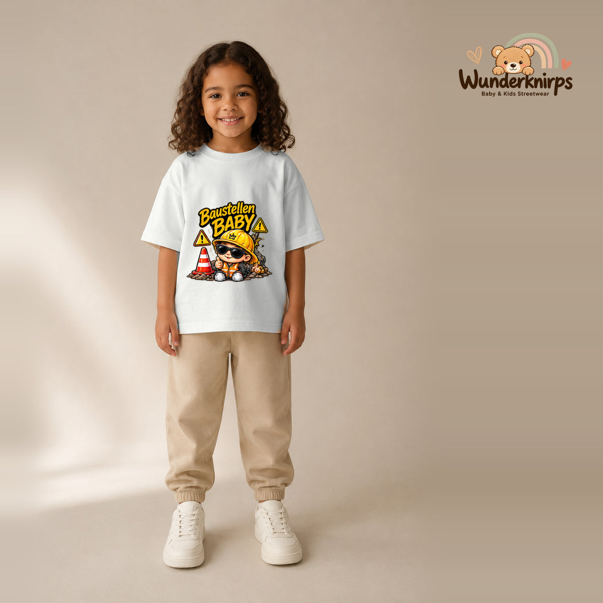 T-Shirt für Mädchen in Weiß mit Motiv „Baustellenbaby“, getragen von einem Kind – Wunderknirps.