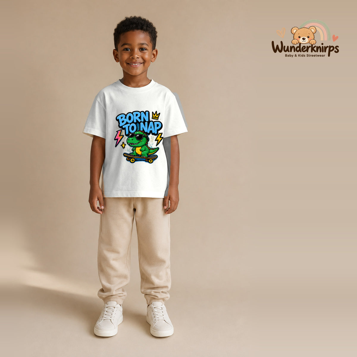 T-Shirt für Jungen in Weiß mit Motiv „Born to Nap“, getragen von einem Kind – Wunderknirps.