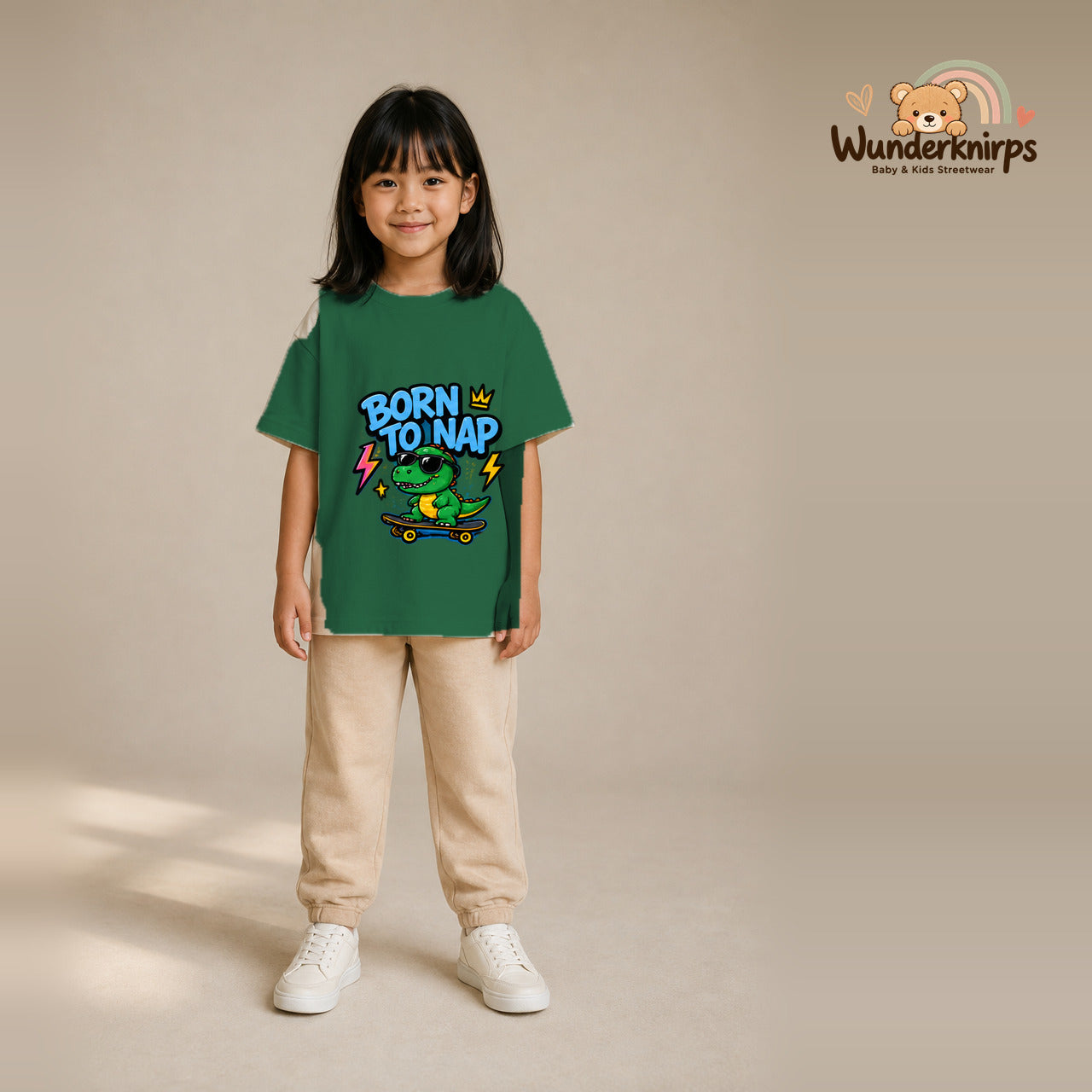T-Shirt für Mädchen in Grün mit Motiv „Born to Nap“, getragen von einem Kind – Wunderknirps.