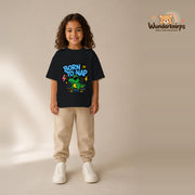 T-Shirt für Mädchen in Schwarz mit Motiv „Born to Nap“, getragen von einem Kind – Wunderknirps.