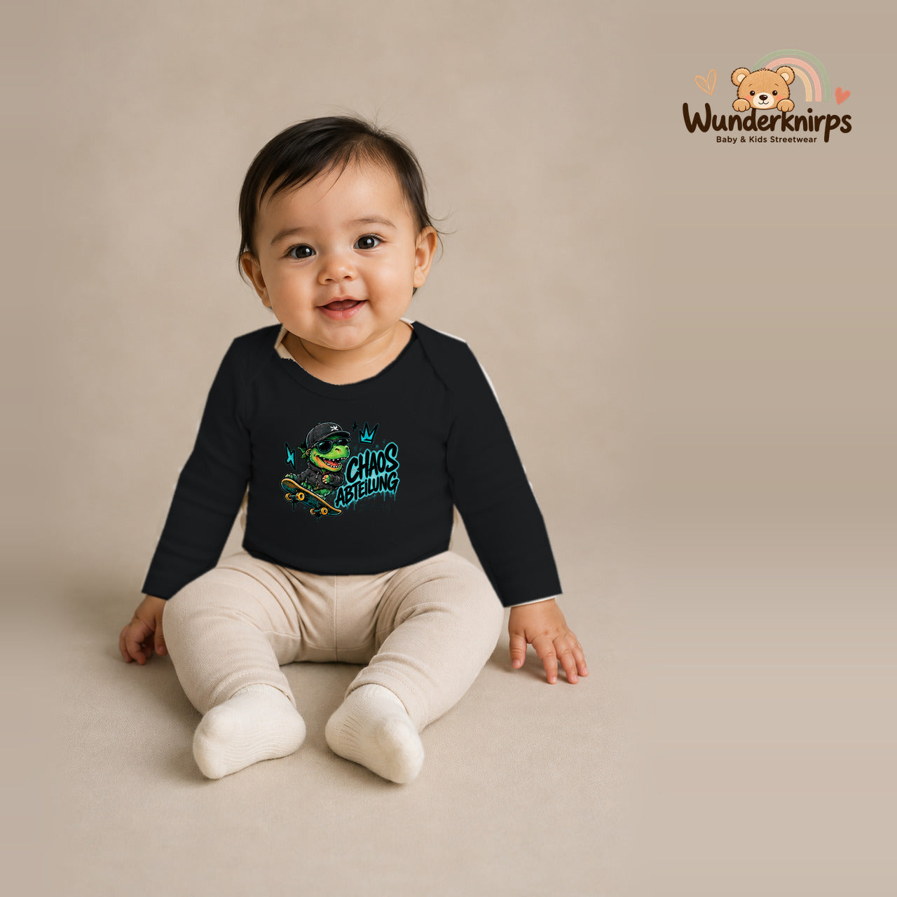 Babybody für Mädchen in Schwarz mit Motiv „Chaos Abteilung“, getragen von einem Kind – Wunderknirps.