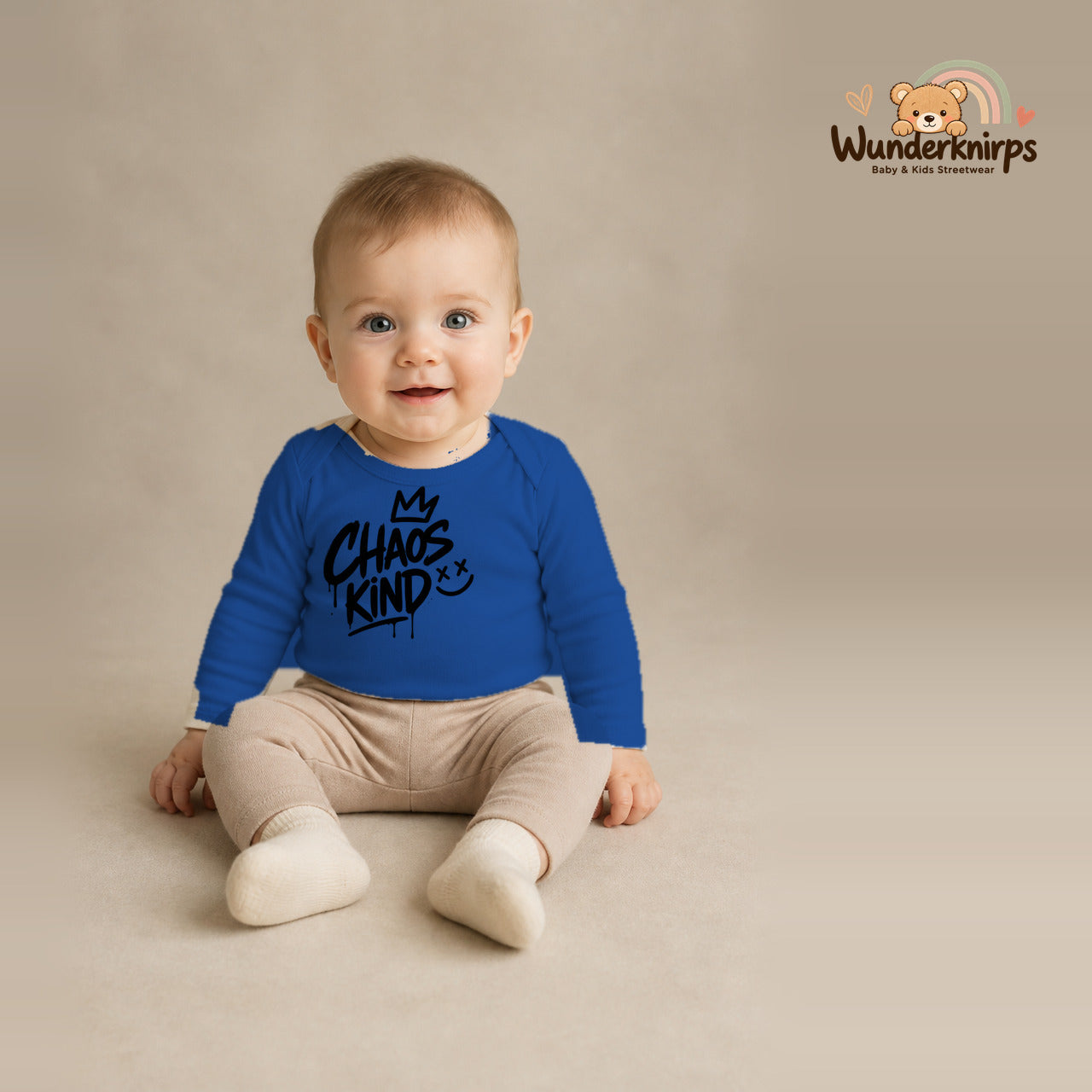 Babybody für Jungen in Blau mit Motiv „Chaoskind“, getragen von einem Kind – Wunderknirps.