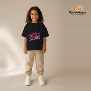 T-Shirt für Mädchen in Schwarz mit Motiv „Cute Outfits“, getragen von einem Kind – Wunderknirps.