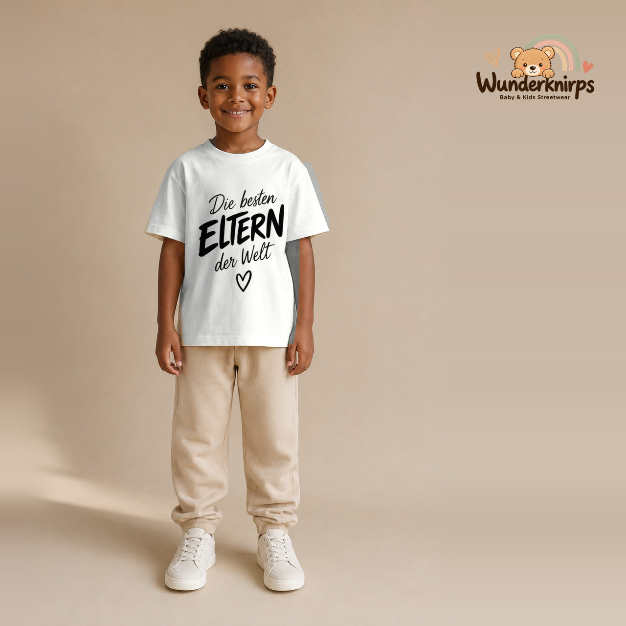T-Shirt für Jungen in Weiß mit Motiv „Die besten Eltern“, getragen von einem Kind – Wunderknirps.