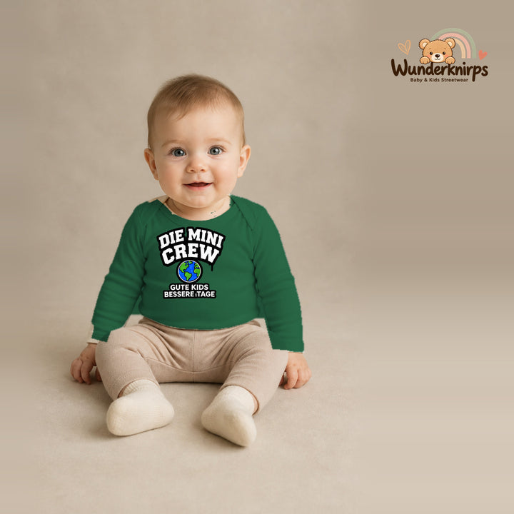 Babybody für Jungen in Grün mit Motiv „Die Mini Crew“, getragen von einem Kind – Wunderknirps.