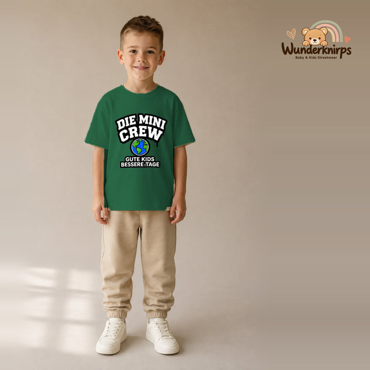 T-Shirt für Jungen in Grün mit Motiv „Die Mini Crew“, getragen von einem Kind – Wunderknirps.