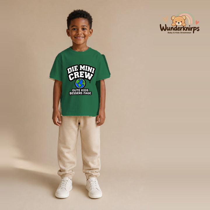 T-Shirt für Jungen in Grün mit Motiv „Die Mini Crew“, getragen von einem Kind – Wunderknirps.