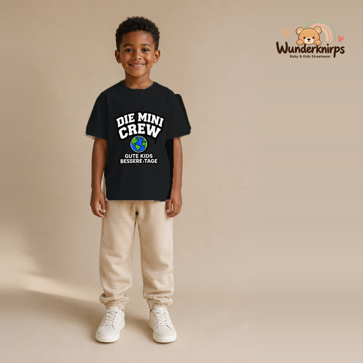 T-Shirt für Jungen in Schwarz mit Motiv „Die Mini Crew“, getragen von einem Kind – Wunderknirps.