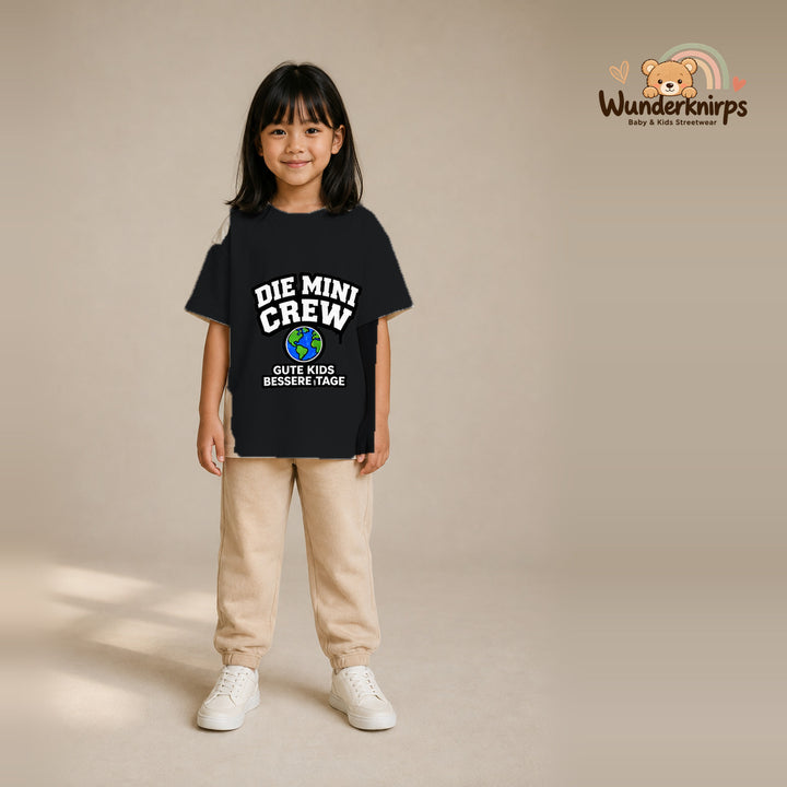 T-Shirt für Mädchen in Schwarz mit Motiv „Die Mini Crew“, getragen von einem Kind – Wunderknirps.