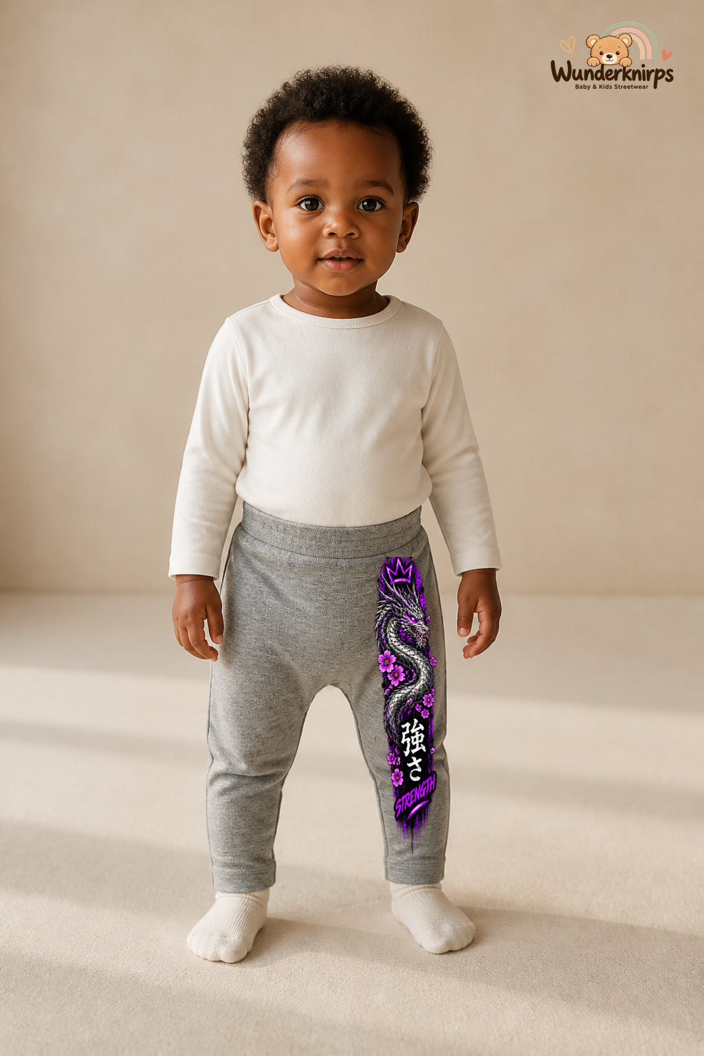 Drachenmotiv Traumlook – Strength – Babyhose für Mädchen: Grau meliert mit Drachenmotiv-Druck am Hosenbein – Wunderknirps.