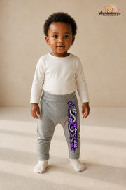 Drachenmotiv Lieblingslook – Drachenmotiv Statement – Babyhose für Mädchen: Grau meliert mit Drachenmotiv-Druck am Hosenbein – Wunderknirps.