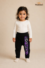 Drachenmotiv Lieblingslook – Drachenmotiv Statement – Babyhose für Mädchen: Schwarz mit Drachenmotiv-Druck am Hosenbein – Wunderknirps.