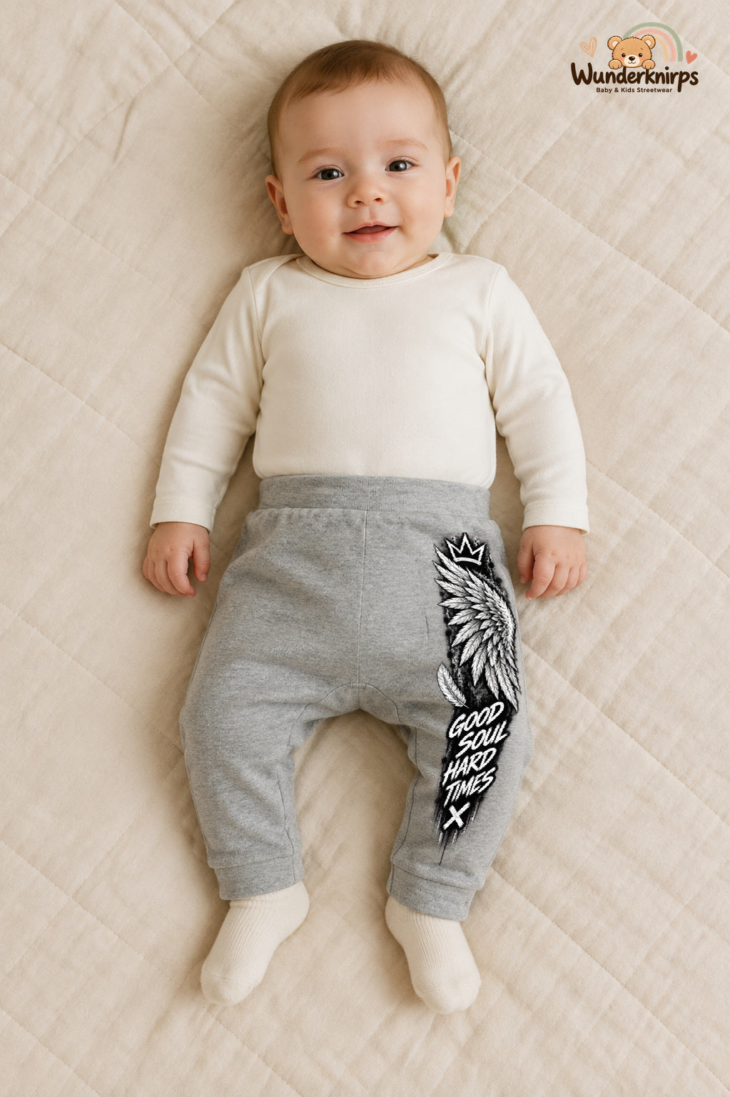 Good soul hard times – Babyhose mit dem Motiv Engelsflügel – für Jungen: Grau meliert mit Engelsflügel-Druck am Hosenbein – Wunderknirps.