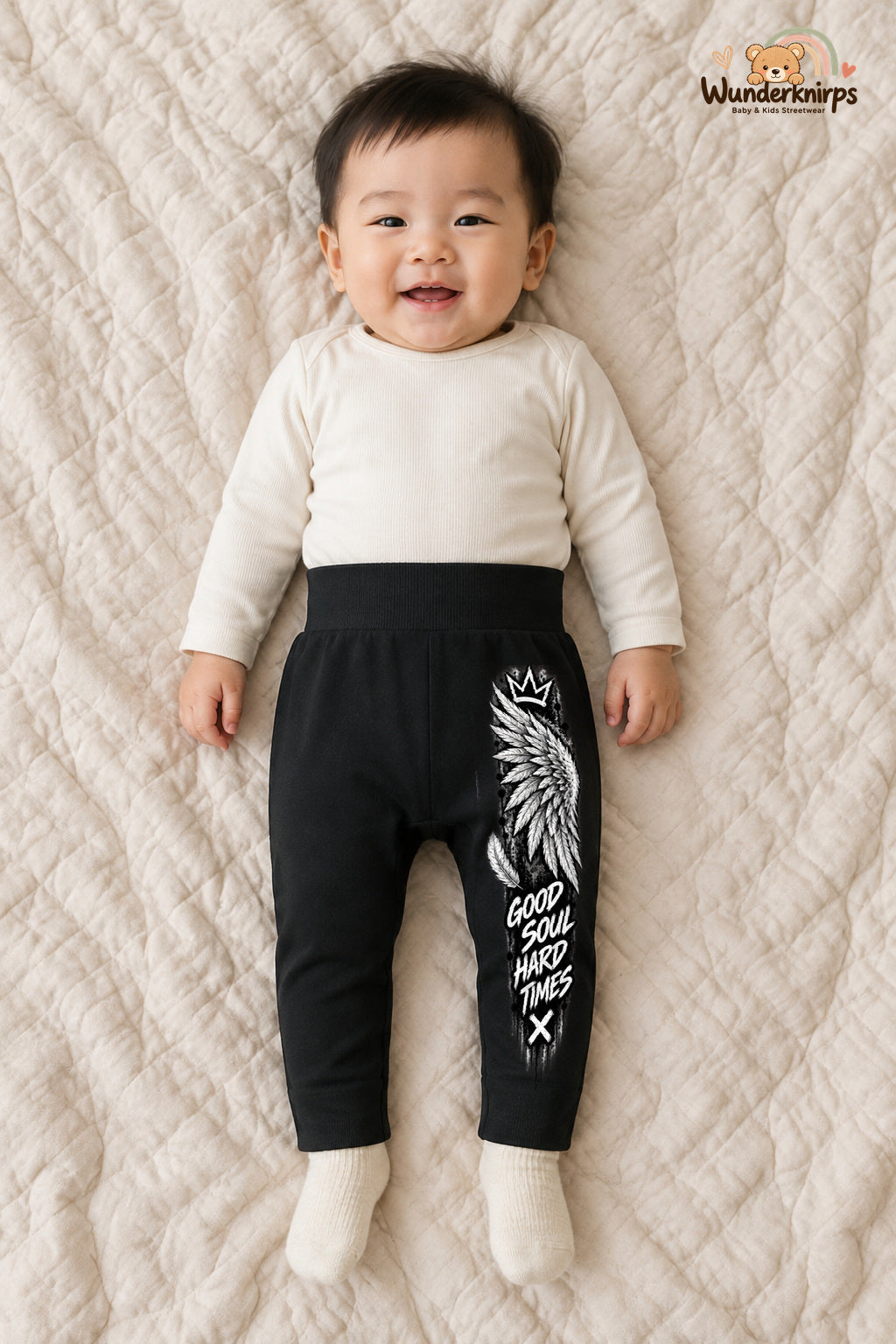 Good soul hard times – Babyhose mit dem Motiv Engelsflügel – für Jungen: Schwarz mit Engelsflügel-Druck am Hosenbein – Wunderknirps.