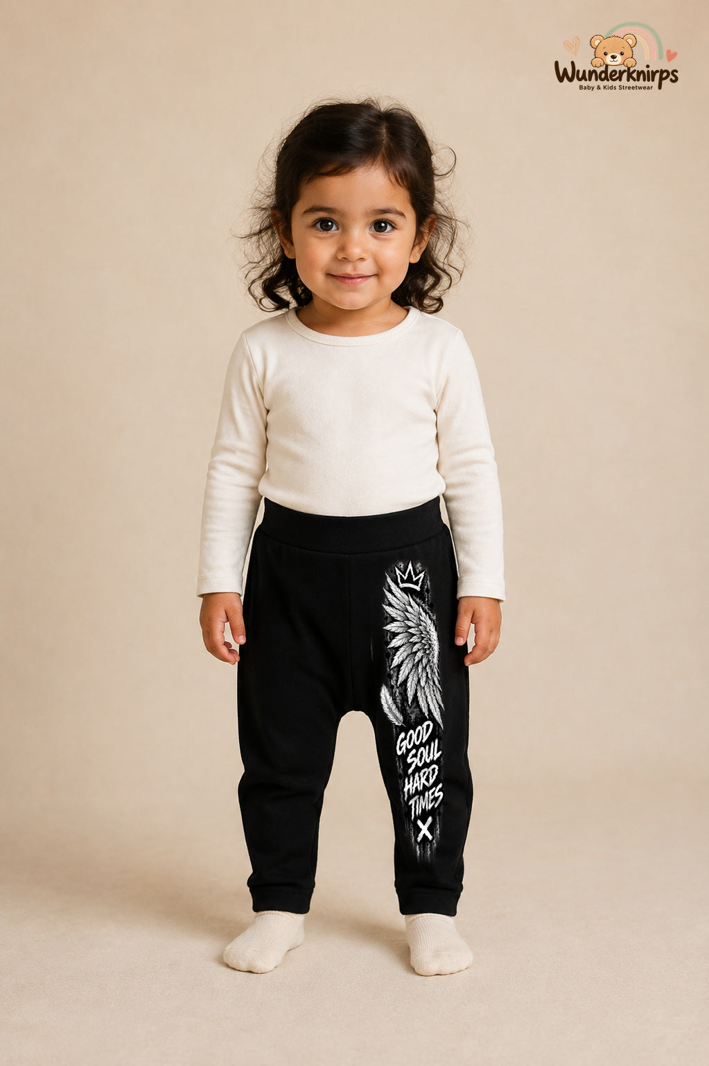 Engelsflügel Lieblingslook – Good soul hard times – Babyhose für Mädchen: Schwarz mit Engelsflügel-Druck am Hosenbein – Wunderknirps.